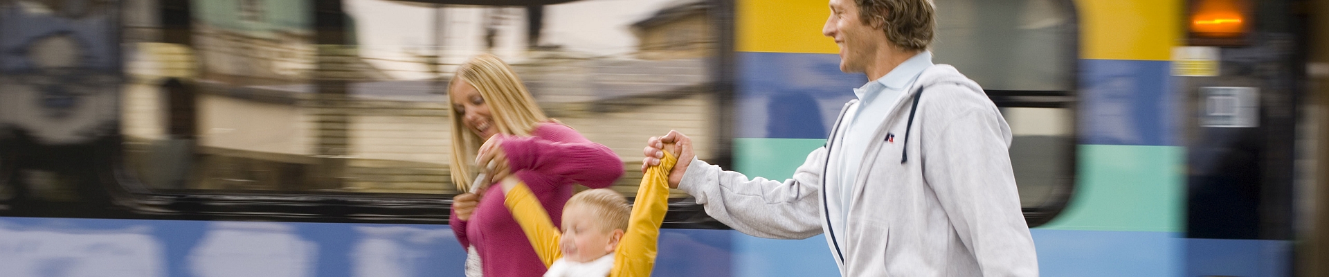 couple swings a young boy on station platform